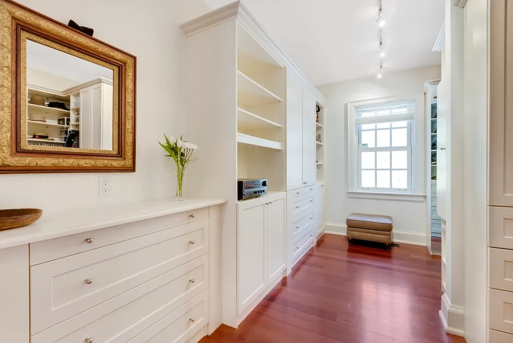 Bright white built-in shelves and cabinets in a calm, organized hallway